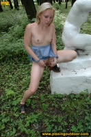 Outdoor pissing on a white statue in a forest