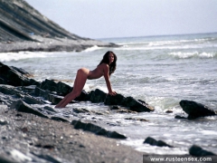 Russian teen brunette poses naked in the sea surf - N